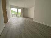 Blick in Wohnzimmer mit grauem PVC-Boden in Laminatoptik und weißen Wänden mit weißen Fenstern und weißer Balkontür - Etagenwohnung mit 57,80 m&sup2; in Meerbusch zur Miete