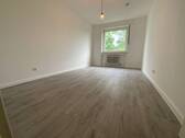 Blick in Schlafzimmer mit grauem PVC-Boden und weißen Wänden mit einem weißen Fenster - 