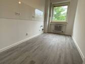 Blick von Diele in Küche mit weißen Fliesenspiegel und weißen Wänden, weißen Fenstern und grauem PVC-Boden - 