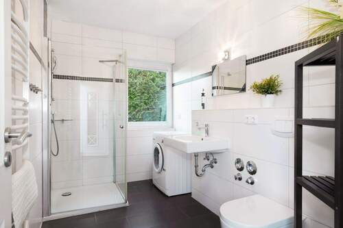 Das gepflegte Badezimmer mit Dusche und Waschmaschine - 