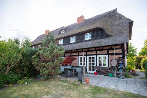 Blick auf eine Haushälfte mit Terrasse und Garten - 