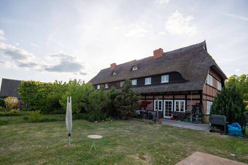Blick auf eine Haushälfte mit Terrasse und Garten - 