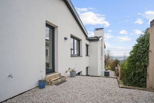 Seitenansicht mit Zugang zum Untergeschoss – hier zeigt sich die wahre Dimension des Anwesens - 