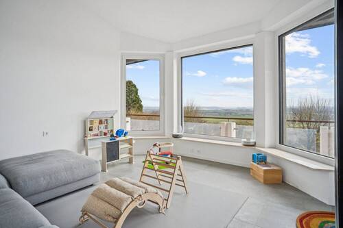 Seitlich angrenzender Raum mit bodentiefen Fenstern und atemberaubender Panoramakulisse - 