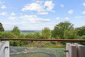 Überdachter Balkon mit spektakulärem Panoramablick über Garten und Landschaft - 