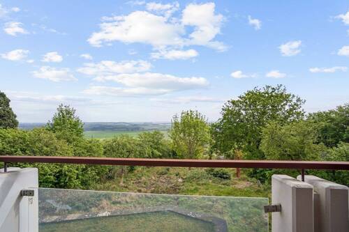 Überdachter Balkon mit spektakulärem Panoramablick über Garten und Landschaft - 