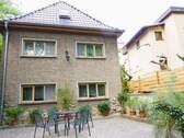 Wohngebäude mit Terrasse - - Einfamilienhaus mit Terrasse, unterkellerten Garagen und Wald -
