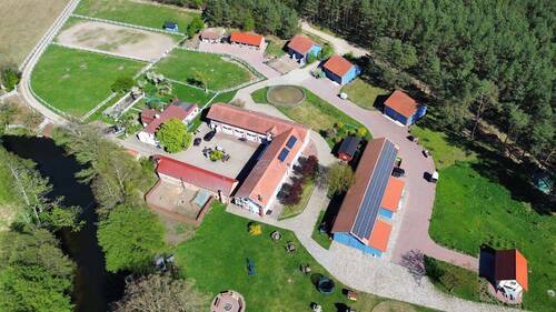 Luftansicht - Tradition trifft Geschäft: Vollbetriebener Hof mit Hotel, Reitstall & Bauland am Fluss nahe Posen