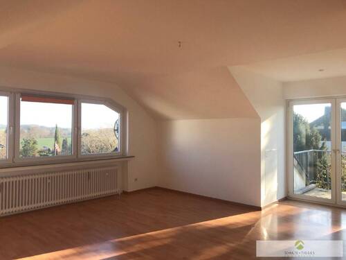 Wohnzimmer zur Dachgeschoss-Wohnung mit Zugang zum Balkon - 