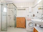 Badezimmer mit bodengleicher Dusche, Waschmaschine, WC und Waschbecken - 2 Zimmer Etagenwohnung in Tettnang