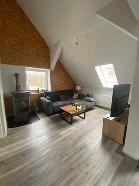 Wohnzimmer mit Pelletofen - HVV Immobilien: Gemütliche Single-Dachgeschoss-Wohnung mit Studio und Pellet-Ofen zu vermieten!