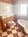 Wannenbadezimmer mit Fenster, Dusche und behindertengerechter Toilette - 