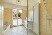 Helles Badezimmer mit Dusche und Badewanne - 