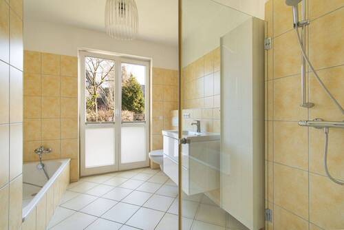 Helles Badezimmer mit Dusche und Badewanne - 