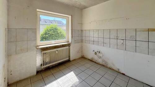 Renovierungsbedürftige Küche mit Fenster zur begrünten Außenanlage - 