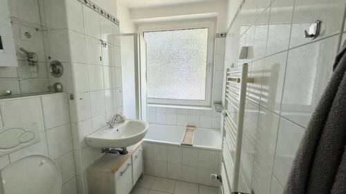 Zeitlos weiss gefliestes Bad mit Fenster - 