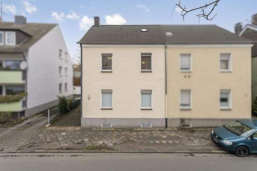 Ansicht Strasse frontal breit_ret - Doppelhaushälfte mit Entwicklungspotenzial und Doppelgarage sowie kleinem Garten.