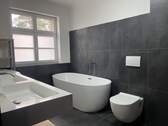 Badezimmer mit Badewanne und Dusche (rechts) - 