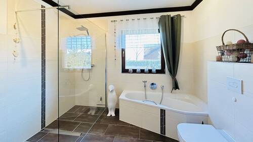 Badezimmer mit bodenebener Dusche und Eckbadewanne - 