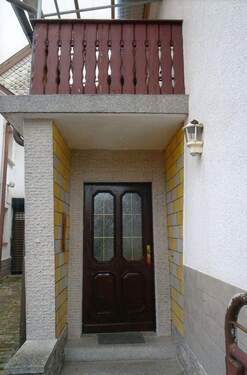 Hauseingang mit darüberliegenden Balkon - 