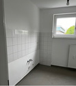 Küche mit Blick zum Fenster mit hellem Fliesenspiegel und grauen Bodenfliesen.PNG - 3 Zimmer Etagenwohnung in Baunatal
