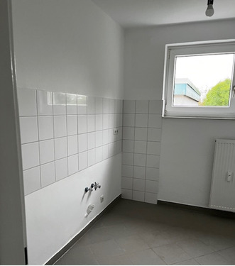 Küche mit Blick zum Fenster mit hellem Fliesenspiegel und grauen Bodenfliesen.PNG - 3 Zimmer Etagenwohnung in Baunatal