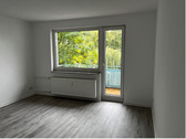 Wohnzimmer mit Blick zu Fenster und Balkontür, helle Wände und heller Bodebelag.PNG - Etagenwohnung mit 69,00 m² in Baunatal zur Miete