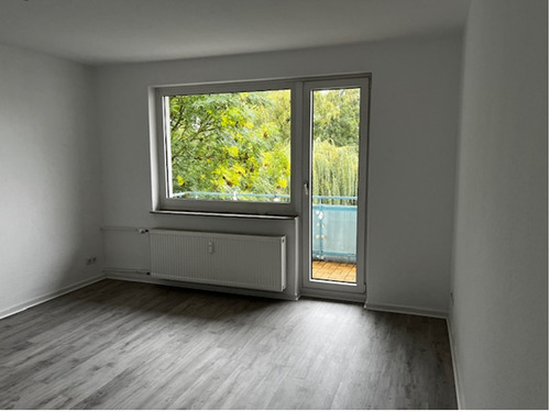 Wohnzimmer mit Blick zu Fenster und Balkontür, helle Wände und heller Bodebelag.PNG - Etagenwohnung mit 69,00 m² in Baunatal zur Miete