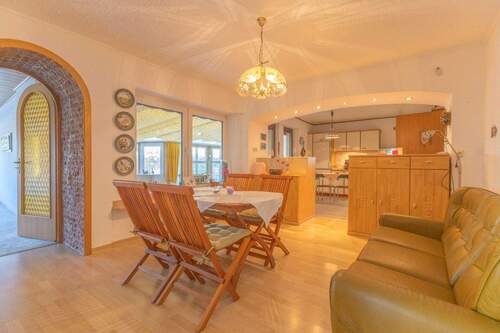 Esszimmer mit offener Küche und Zugang zum überdachten Außenbereich - 