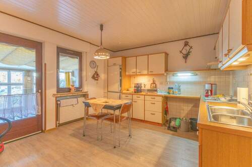 Esszimmer mit offener Küche und Zugang zum überdachten Außenbereich - 