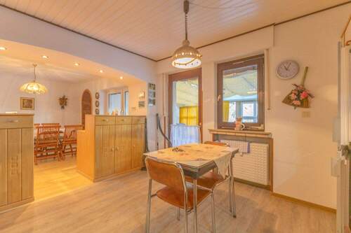 Esszimmer mit offener Küche und Zugang zum überdachten Außenbereich - 