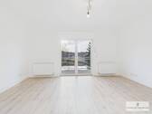Großzügiger Wohnbereich mit direktem Zugang zum Balkon - 'Modernisierte, lichtdurchflutete Wohnung mit Balkon, Einbauküche & Garage'