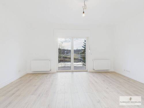 Großzügiger Wohnbereich mit direktem Zugang zum Balkon - 'Modernisierte, lichtdurchflutete Wohnung mit Balkon, Einbauküche & Garage'