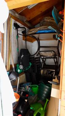 Gartengerätehauschen hinter Holzlager - 