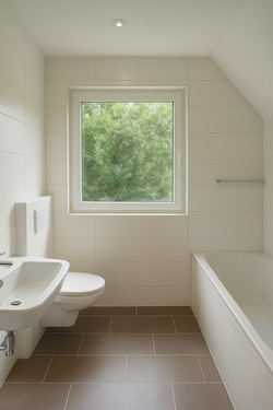 Moderne Badezimmeransicht mit grünem Ausblick - 