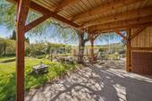 überdachte Terrasse mit Blick in den Garten - 