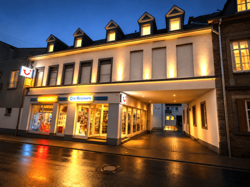 Abendliche Straßenszene mit Reisebüro.png - 2-Zimmer-Wohnung im 1. Obergeschoss Einbauküche Ohne Balkon Ohne PKW-Stellplatz