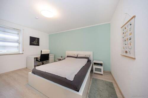 Erdgeschosseinheit: freundliches Schlafzimmer - 