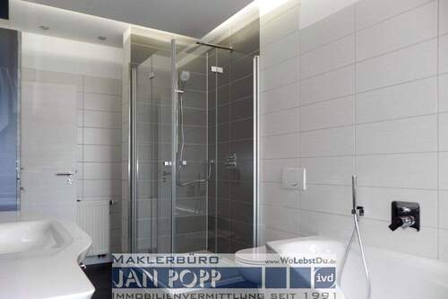 Tageslichtbad mit Eckwanne, Duschkabine und Badmöbeln - 