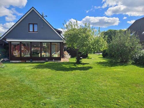 Rückansicht auf die Immobilie mit Wintergarten - Einfamilienhaus mit 131,00 m² in Horstedt zum Kaufen