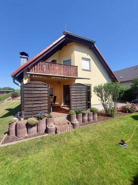 Hausansicht mit Terrasse und Balkon - 