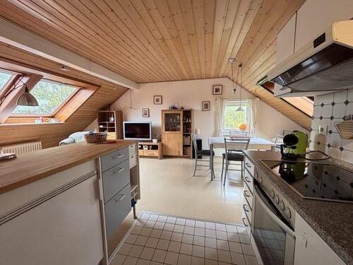 Blick in den gemütlichen Wohnraum mit Einbauküche - Flexibel wohnen unterm Dach: Voll möbliert - ideal für Monteure, Mitarbeiter oder Selbstnutzer