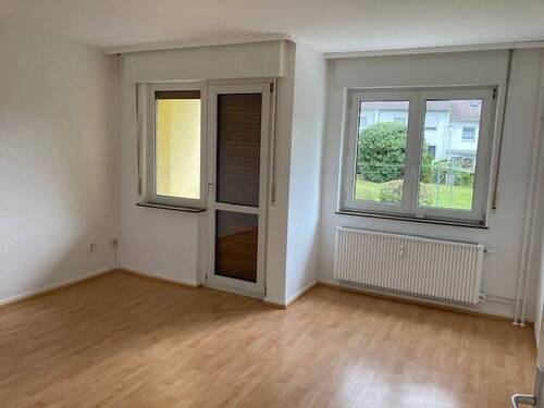 Wohnzimmer mit Zugang zum Balkon und hochwertigem PVC-Belag in Holzoptik - 2 Zimmer Etagenwohnung zur Miete in Bad Vilbel