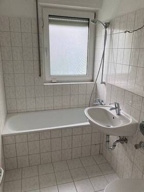 Bad mit Fenster, weißen Sanitärobjekten, weißen Wand- und Bodenfliesen - 2 Zimmer Etagenwohnung in Bad Vilbel