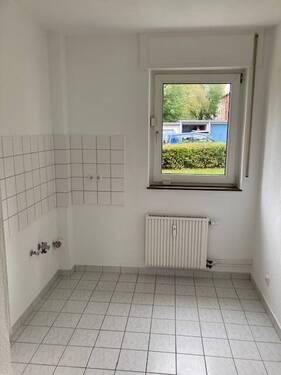 Küche mit Blick ins Grüne, weißem Fliesenspiegel und weißen Bodenfliesen - 