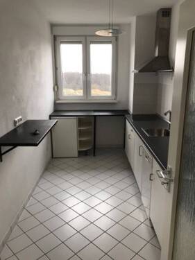 Küche mit Blick ins Grüne, weißem Fliesenspiegel und weißen Bodenfliesen - Etagenwohnung mit 60,10 m&sup2; in Friedrichsdorf zur Miete