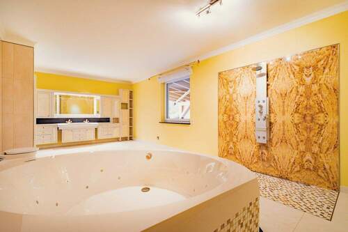 Wellnessbadezimmer mit Regenfalldusche und Whirlpoolbadewanne - 