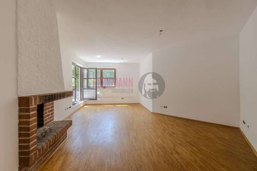 Wohnzimmer mit Kamin - 3 Zimmer Split-Level Gartenwohnung mit Sauna und Tiefgaragenstellplatz in ruhiger Lage