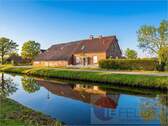Außenansicht - Kleinod zum Wachküssen mit Idylle pur: Fehnhaus direkt am Wasser mit Scheune, Garage & großem Garten