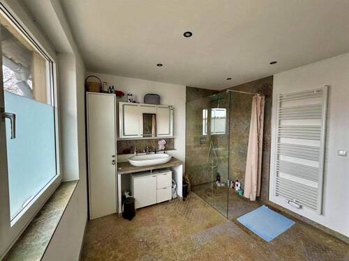 Badezimmer mit ebenerdiger Dusche und Handtuchheizkörper im ersten Obergeschoss - 